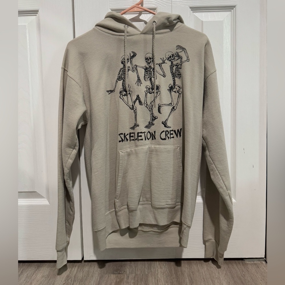 Small, tan hoodie with skeletons.